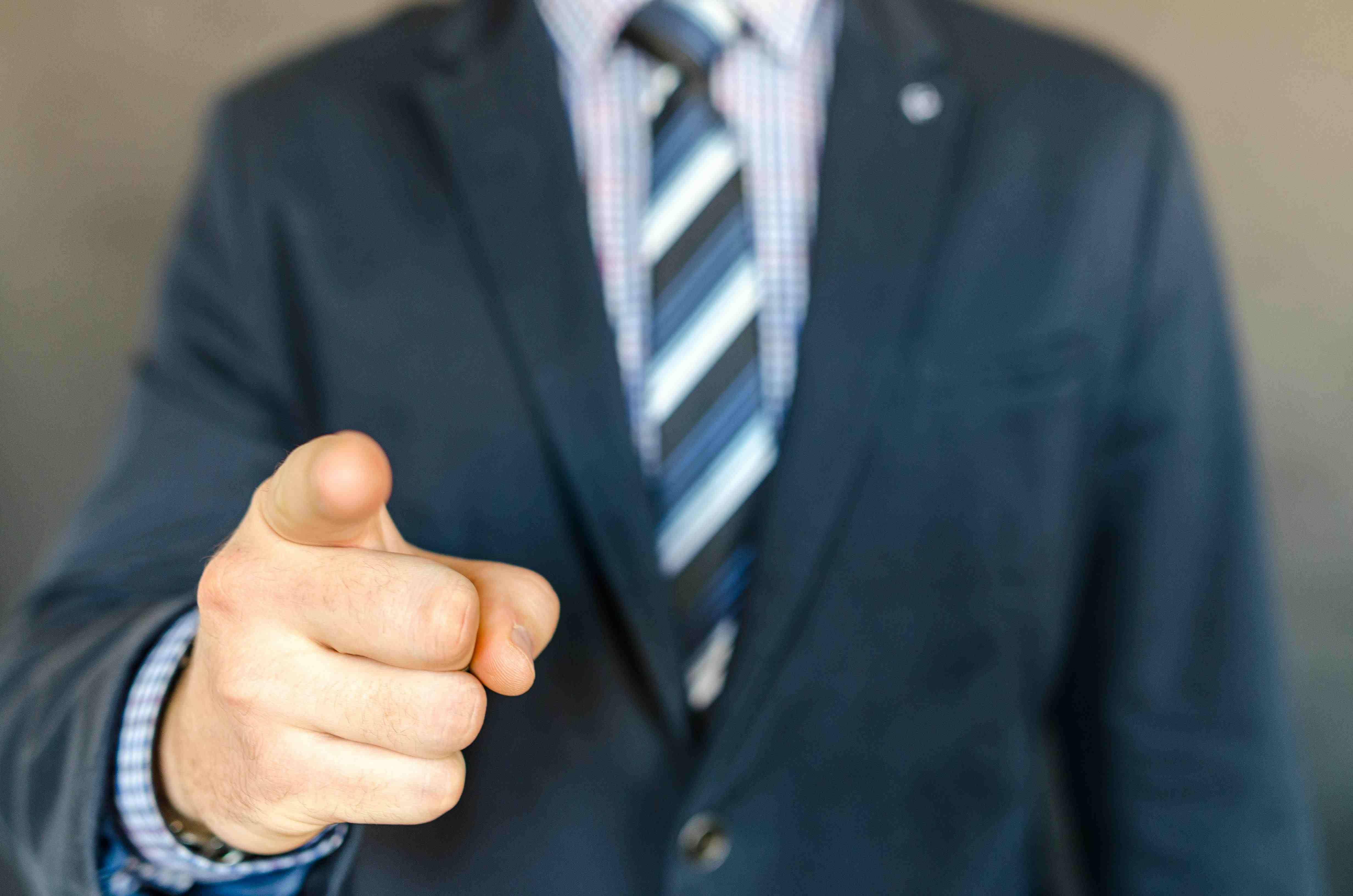 Professional businessman in suit extending hand for handshake representing successful M&A deal completion